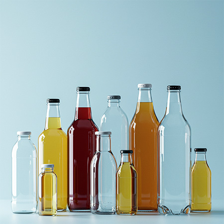 Boissons Image d'ambiance : Bouteilles en verre remplies de boissons sur un fond bleu clair