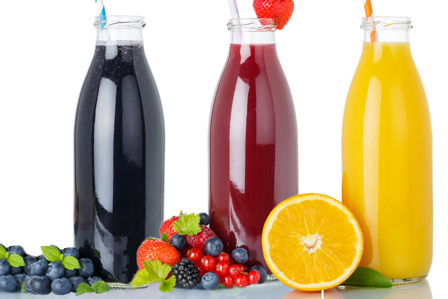 Recette Smoothie aux fruits noir-rouge-or Groupe de trois bouteilles transparentes à large goulot remplies de smoothies noirs, rouges et jaunes et d'une paille chacune, décorées de fruits
